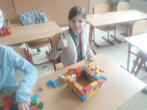 Detské ruky stavajú vežu z drevených kociek