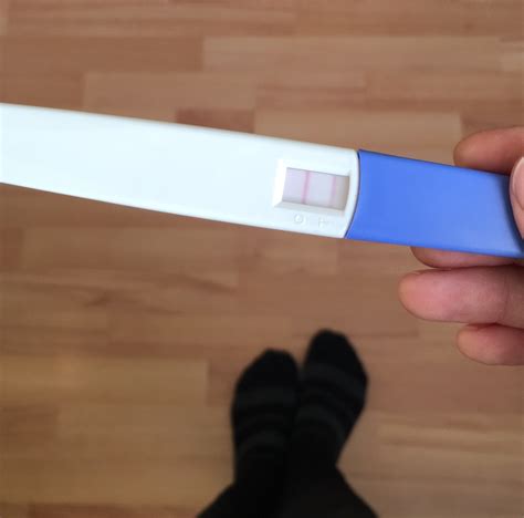 žena držiaca pozitívny tehotenský test