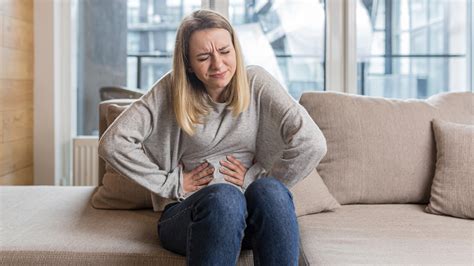 Žena držiaca brucho s výrazom bolesti