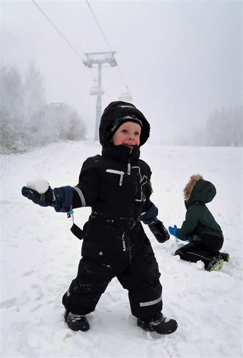 Dieťa v zimných rukaviciach, ktoré sa hrá v snehu