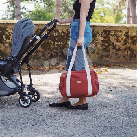 žena s dieťaťom a prebaľovacou taškou na kočíku