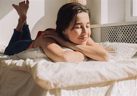 Žena ležiaca na boku v posteli, s rukou na bruchu