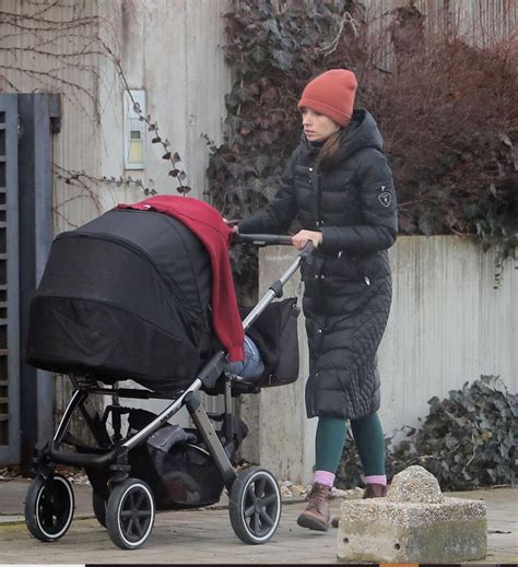 Dieťa na prechádzke s kočíkom a rodičom používajúcim držiak na tašku