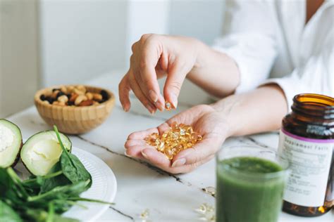 Žena držiac v ruke vitamínové doplnky