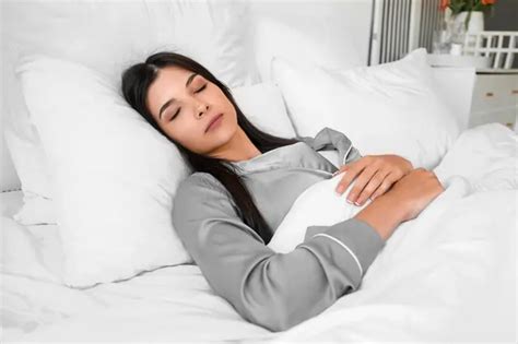 žena objíma vankúš v posteli