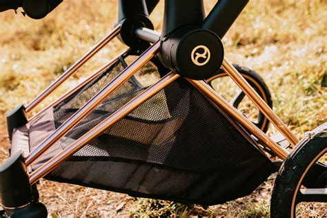 Detailný záber držiaka na pohár upevneného na rukoväti kočíka Cybex